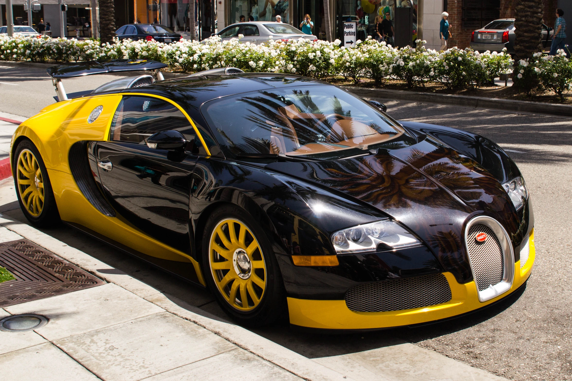 a black and yellow bug is parked on a street