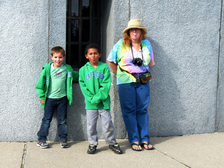 two children and a woman in front of a building