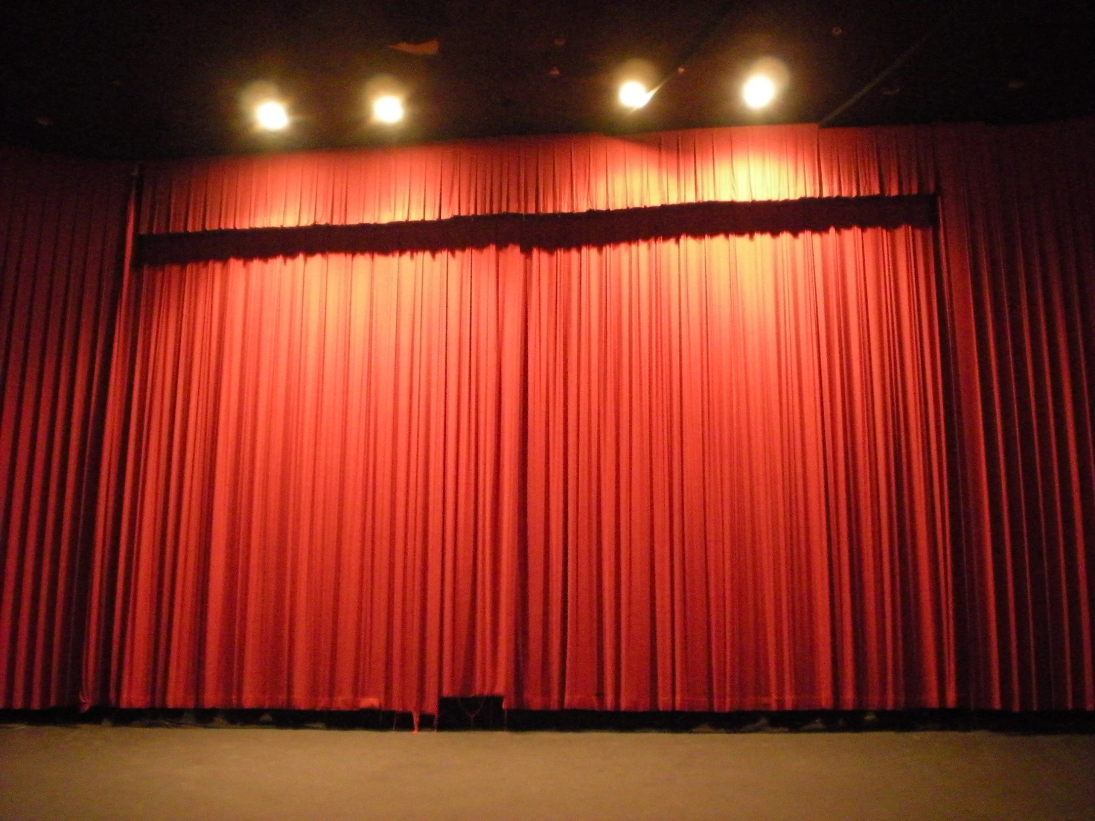 a scene with lighting and red curtains