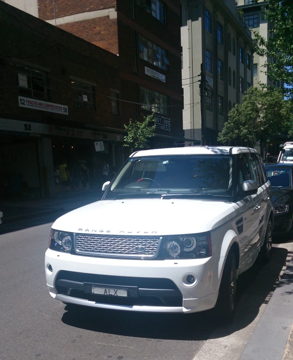 a white car parked in front of buildings on a street