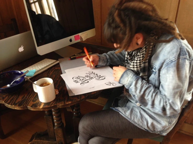 a young woman sitting on a chair and drawing