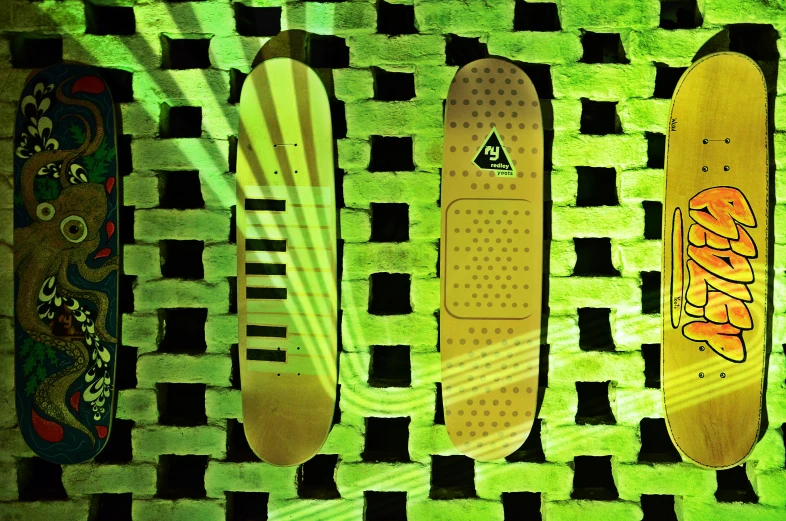 four skateboards on a wall with green and white stripes
