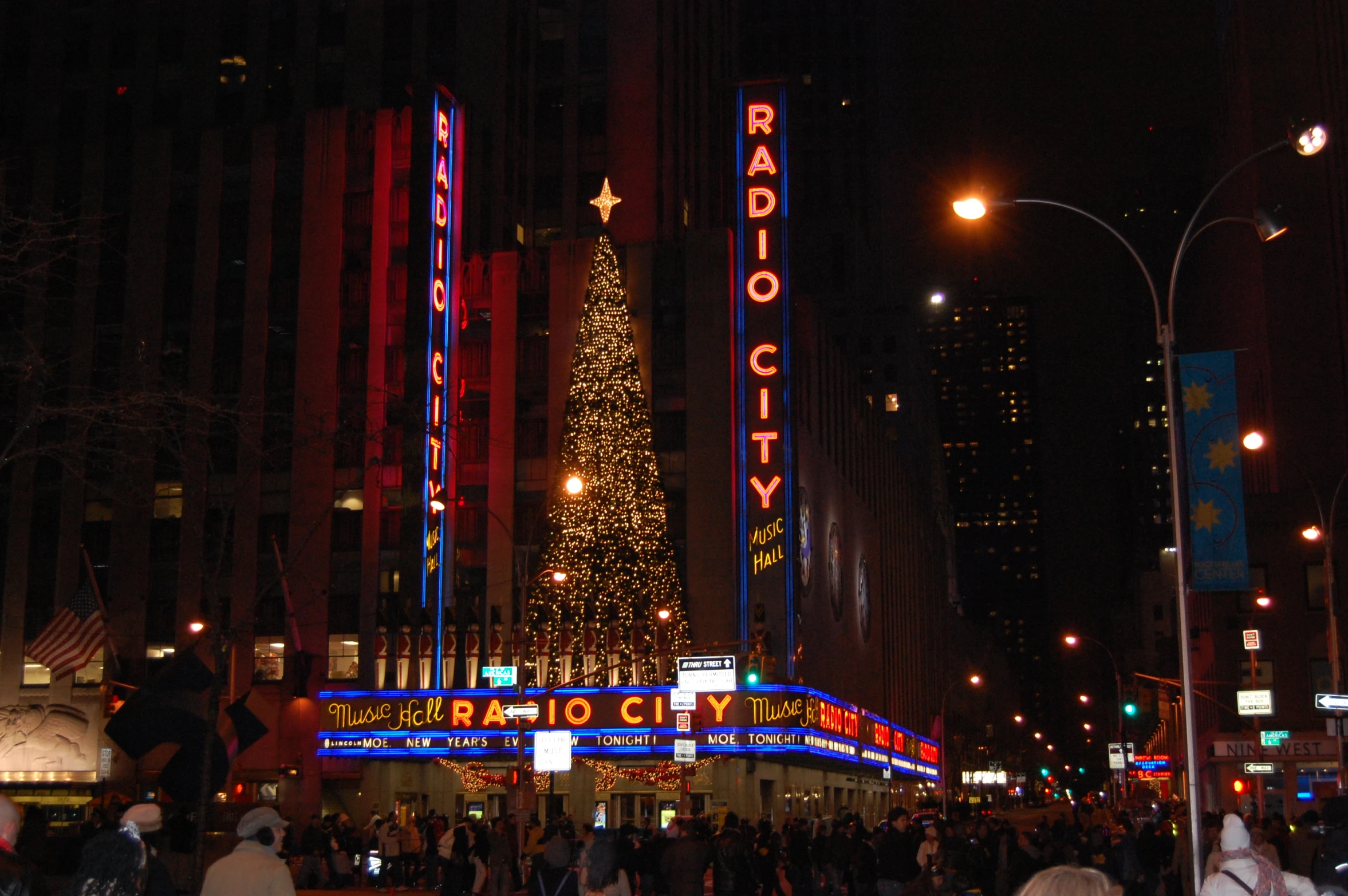 a christmas tree is lit up in front of radio city