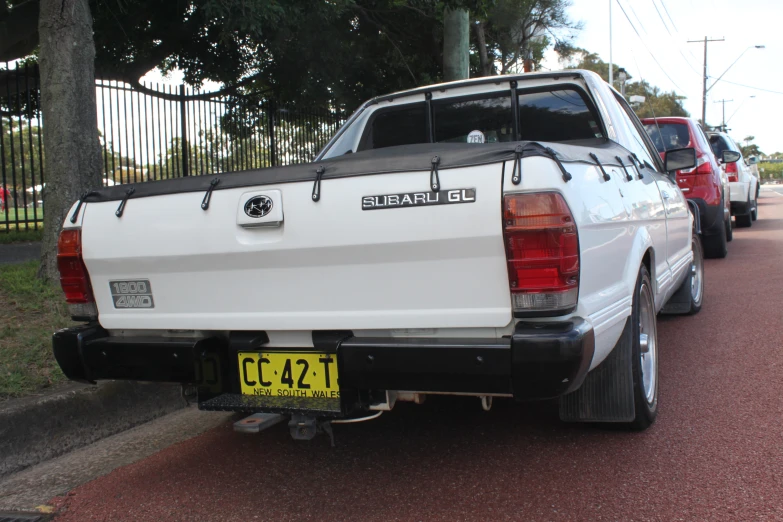 some white cars are parked on the street