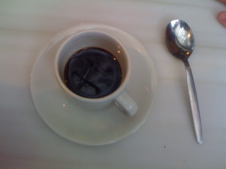 a cup of coffee with spoon on plate