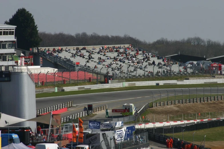 many race cars racing around a track with many stands