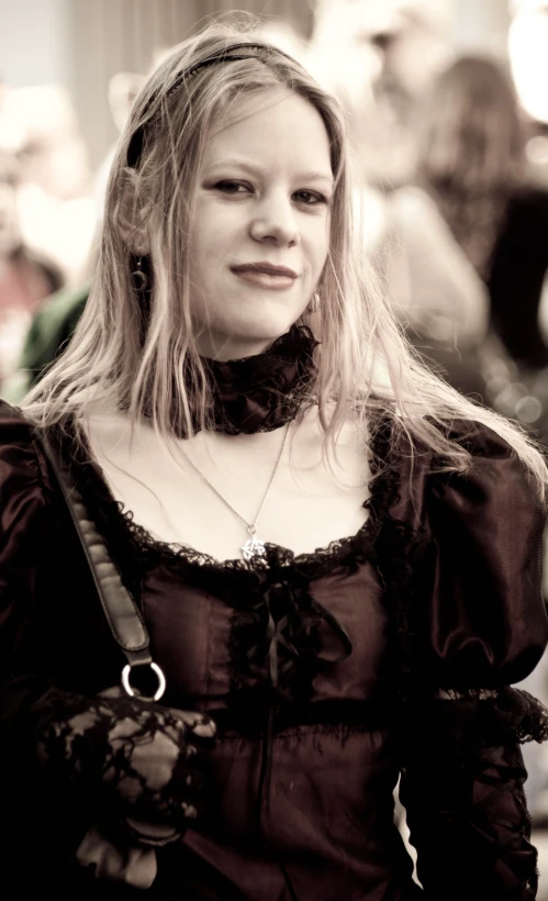 a lady with a black shirt and a bag smiles into the camera