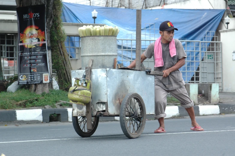 man hing a cart that includes items on the back