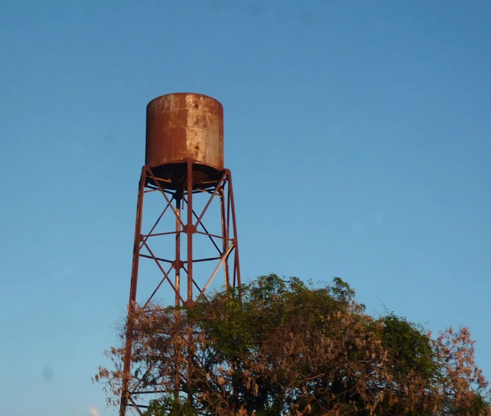 an old rusty water tower in a park