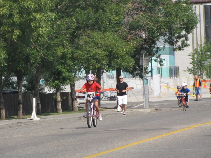 a man and girl riding their bikes on the road