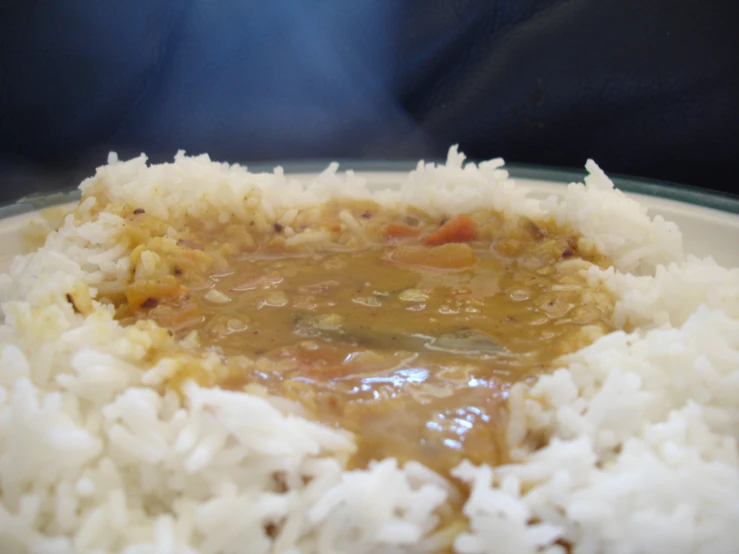 rice and meat covered in gravy on top of a white plate