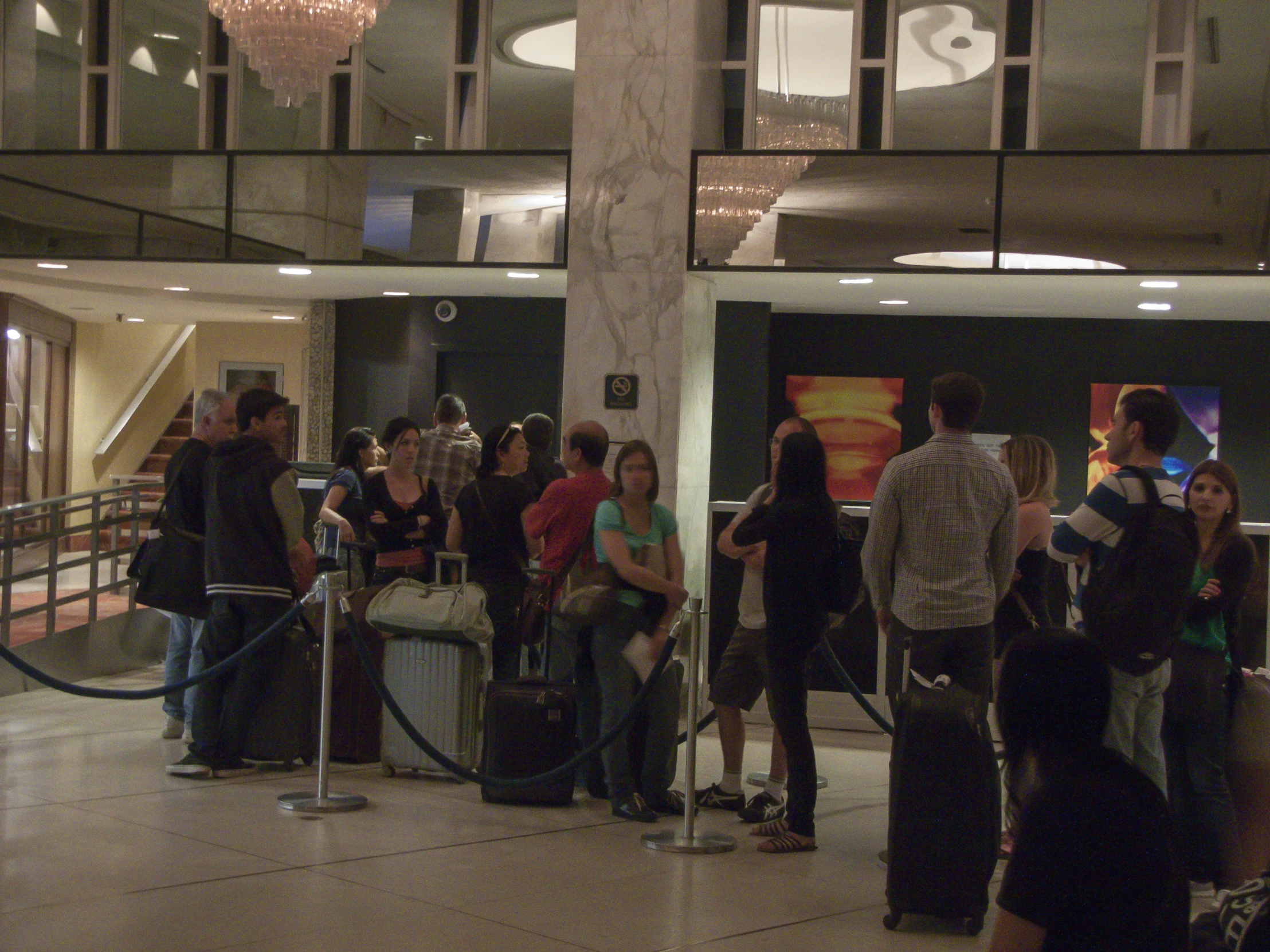 several people waiting in line at the check in desk