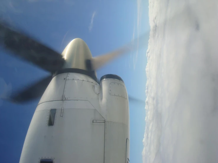 an airplane wing flying over clouds in the sky