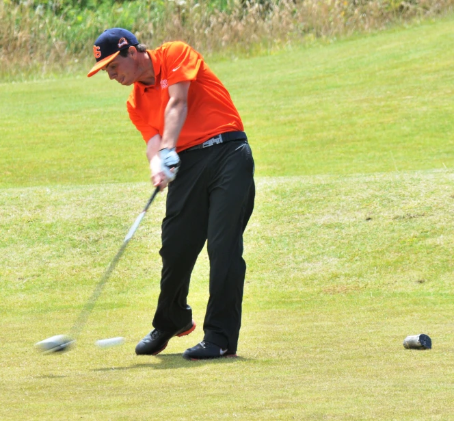 a person playing golf on a field with no helmet