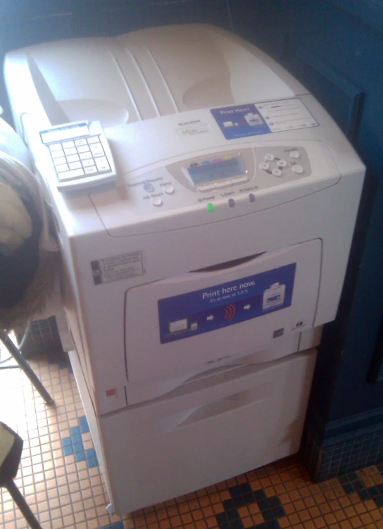 an office printer and fax is on a tiled counter