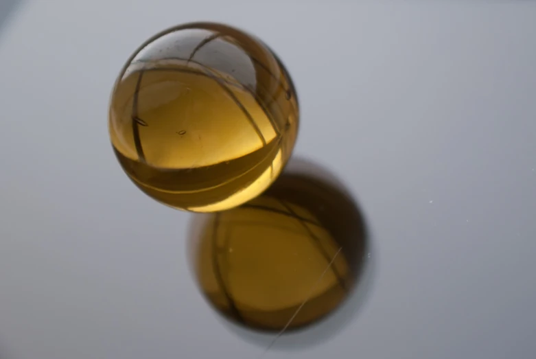 the reflection of two yellow glass balls on a white surface