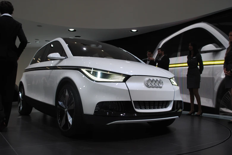 an all white car sitting on display at a show