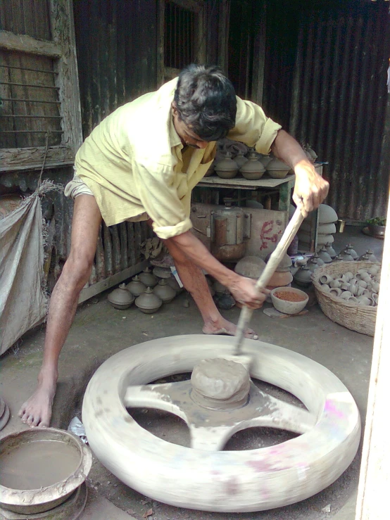 a man uses a big hammer to shape an object