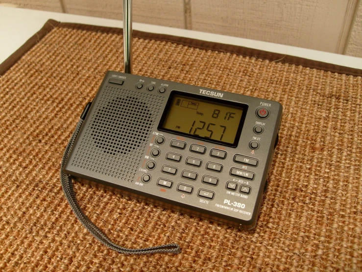 a radio and a clock are set on an orange rug