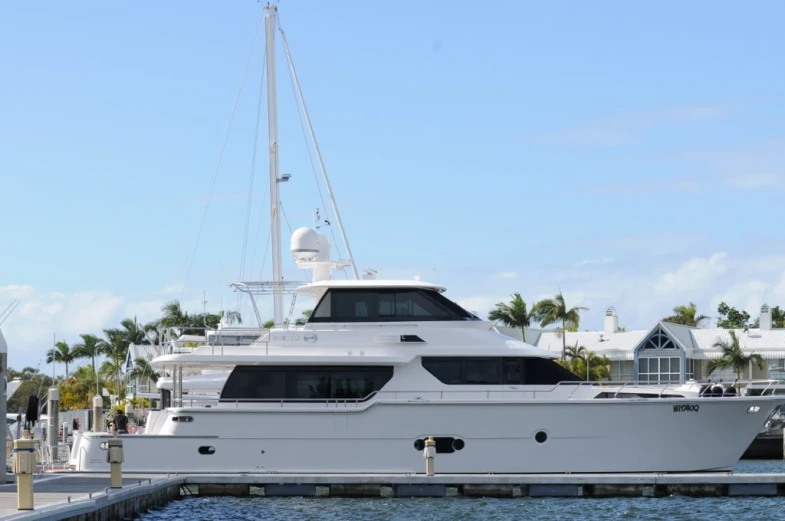 white yacht parked on the side of the pier near the house