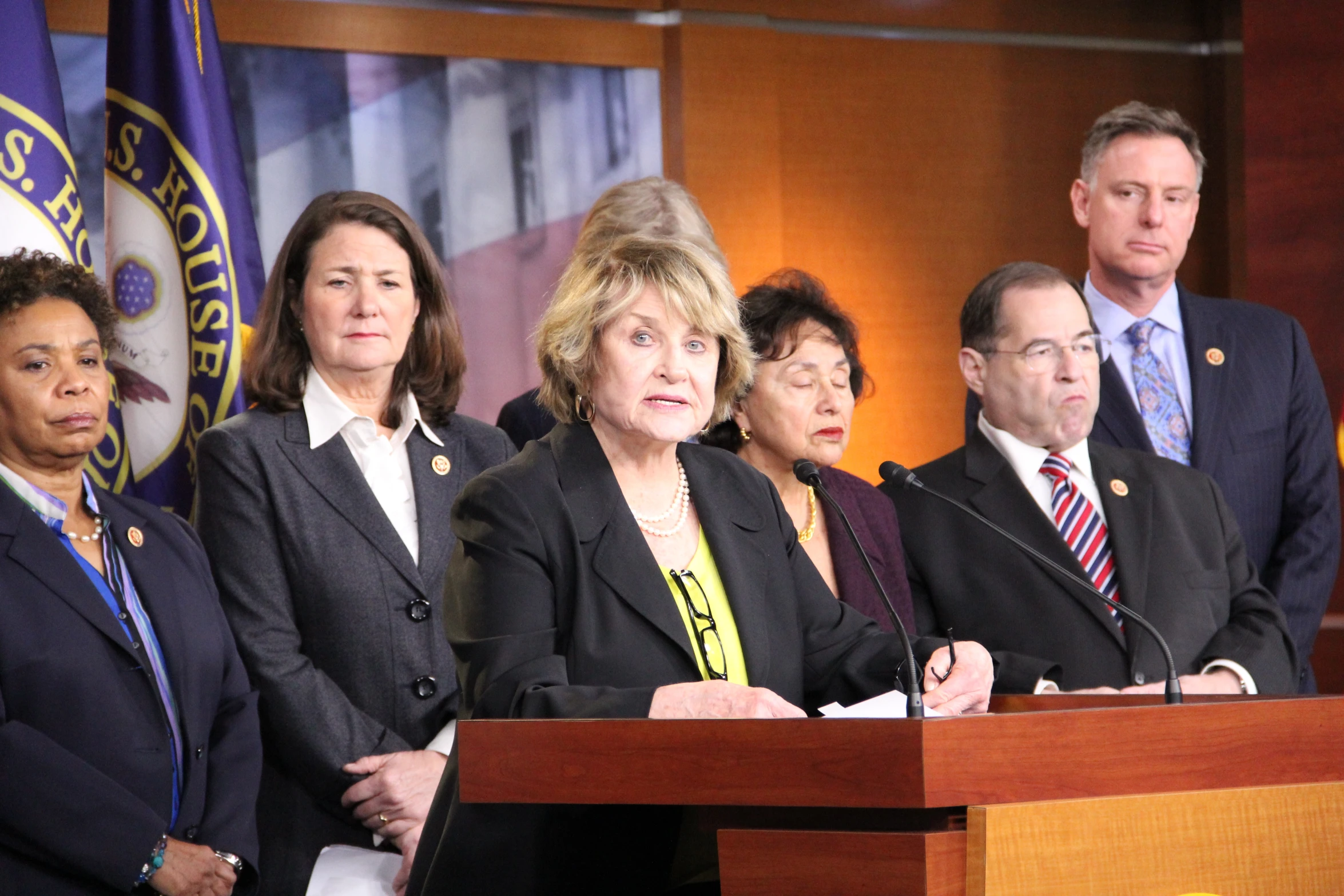 several people stand behind a microphone on stage