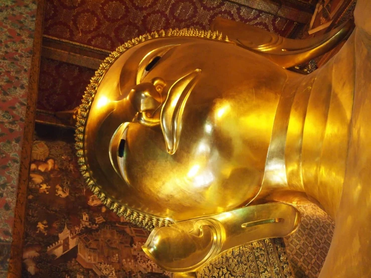 a golden statue in a building next to a rug