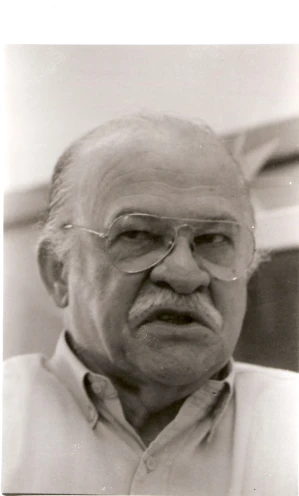 an old man wearing glasses and a white shirt