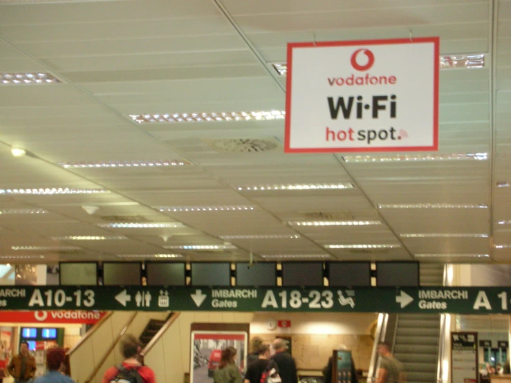 people walk through an airport terminal at night