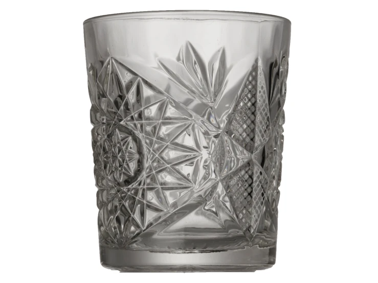 a glass with designs on it sitting on top of a white surface