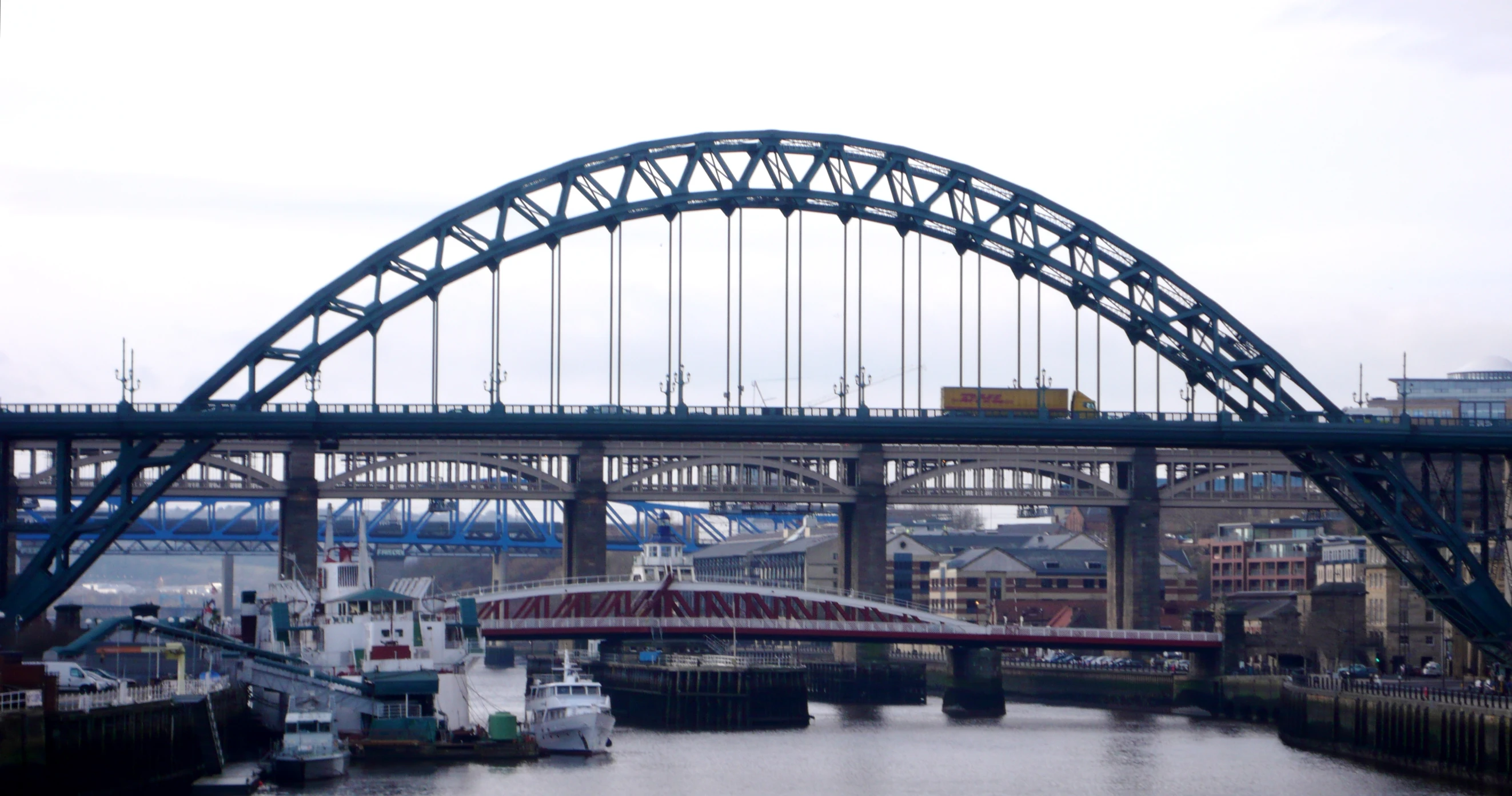 boats floating down a river under an arched bridge