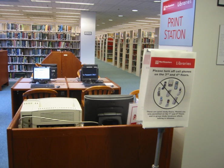 there is a book shelf with books and office supplies on it