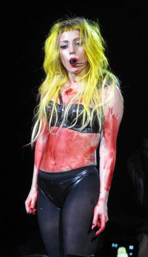 lady in high - waisted leggings and a short top with white paint dripping off the bottom