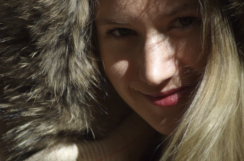 a woman with long blond hair and fur coat