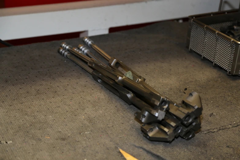 some metal parts laying on the floor with a screw wrench