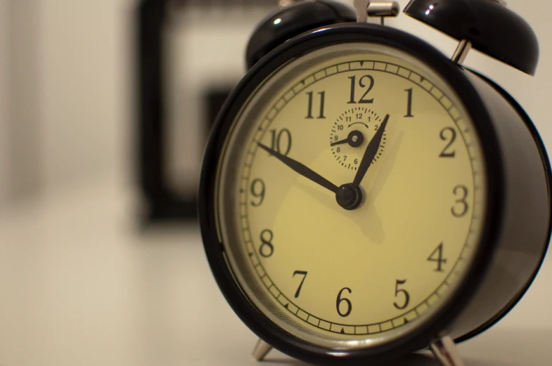 an alarm clock sits on a counter near some magnets