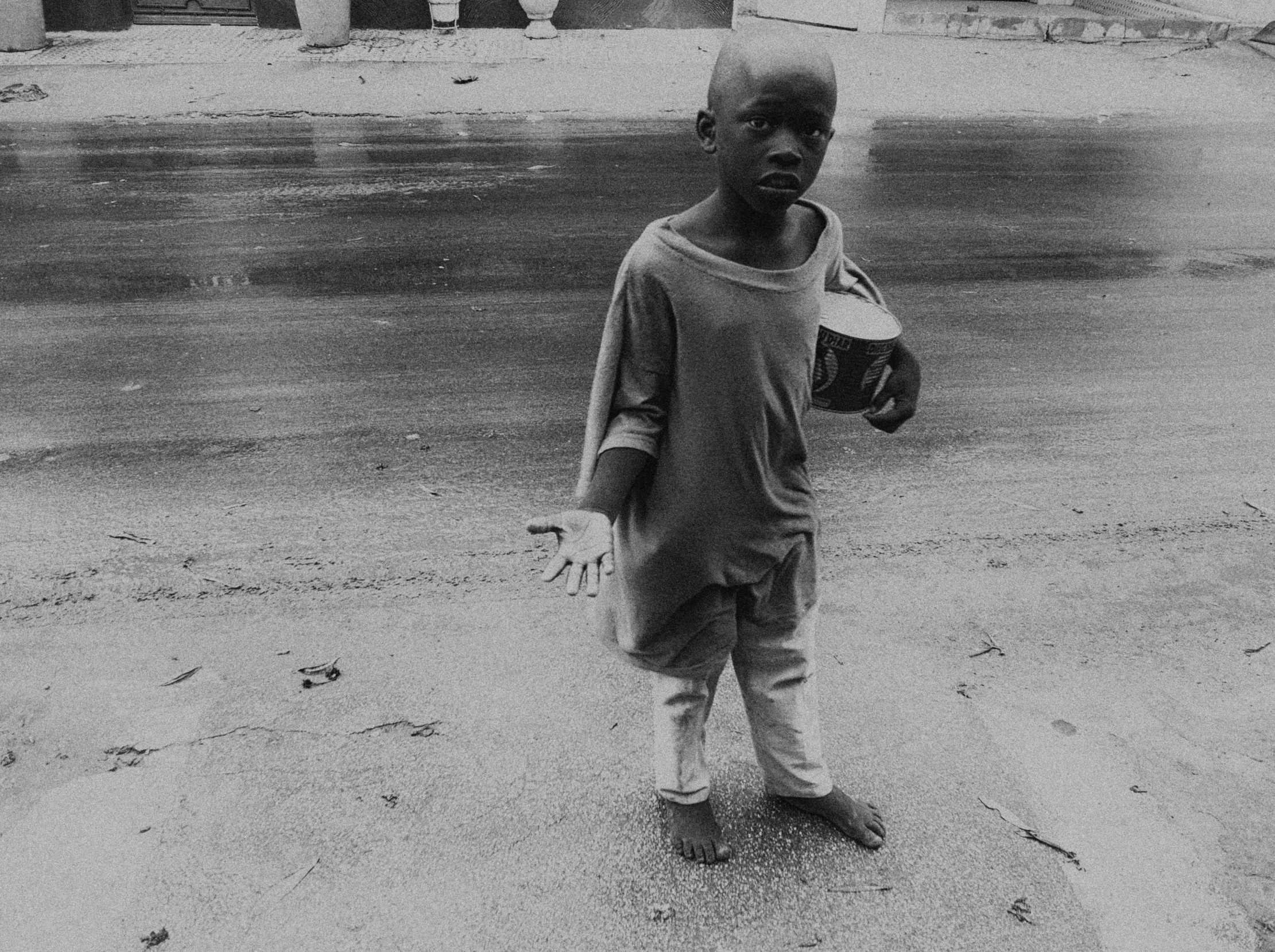 a child stands in the dirt holding a baseball glove