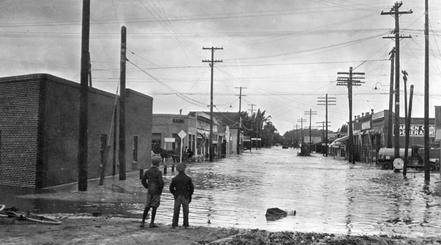 black and white po of people standing in flood