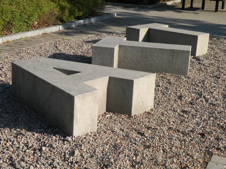 concrete benches lined up on top of the gravel