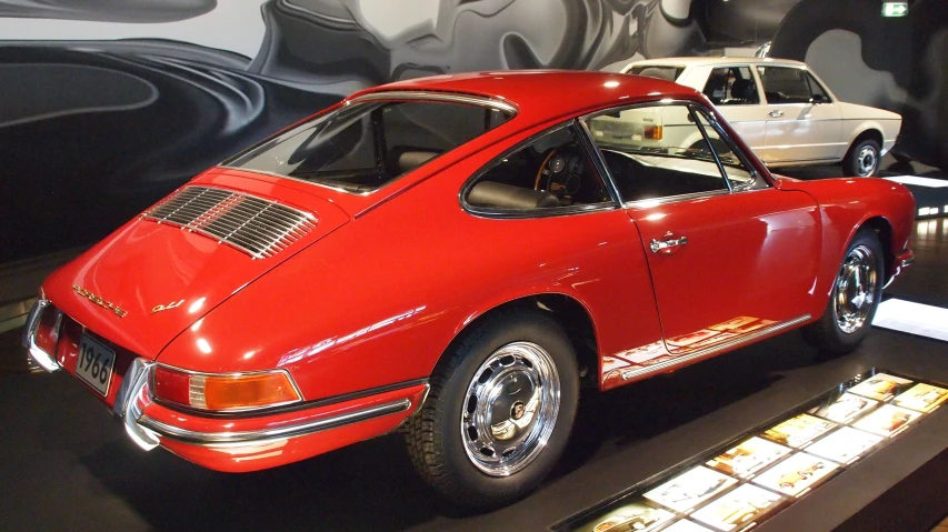 a large red porsche on display in a museum