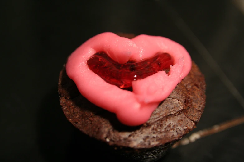 pink icing on chocolate cookies shaped like a heart