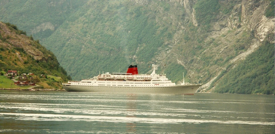 a cruise ship sailing on the river through mountains