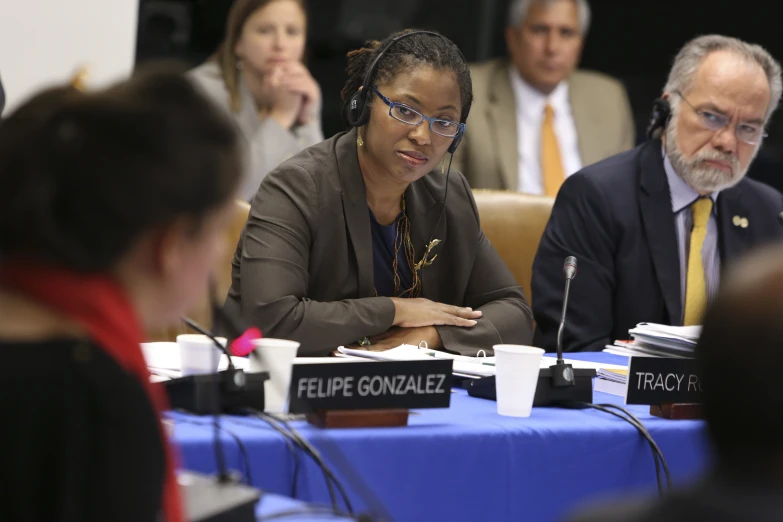 a woman is speaking at the table with others