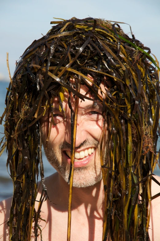 a man smiles as he stands by the ocean