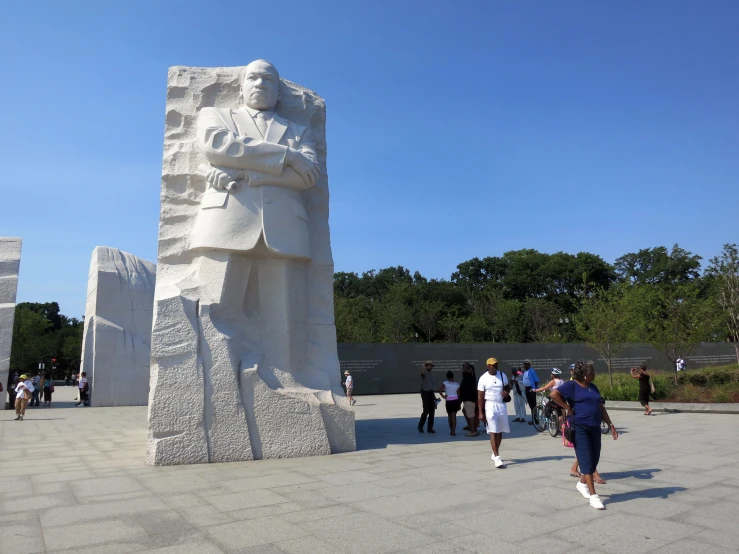 a group of people standing around a tall statue