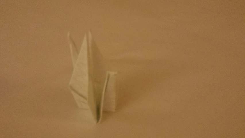 a paper boat floating over some brown background