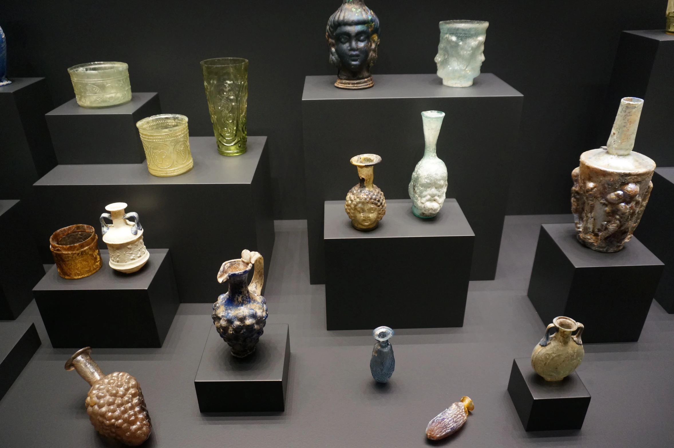 several glass bottles and some figurines are on display