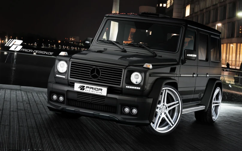 a mercedes g class vehicle parked in front of a city skyline