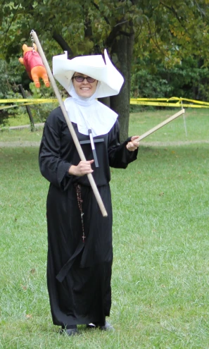 a nun walking in the grass with a staff