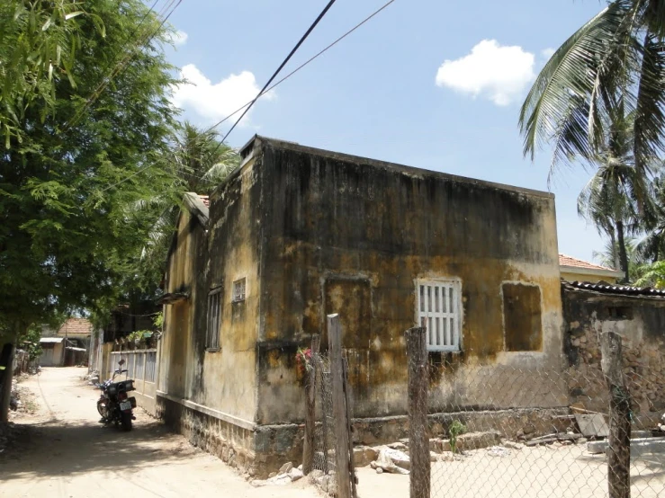 an old, rusty building with windows sits in the middle of the street