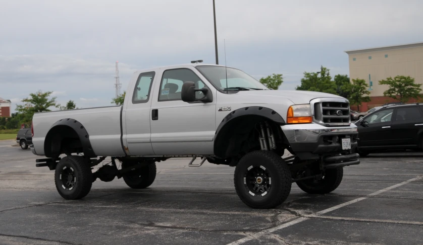 a big white truck with large tires on the flat bed